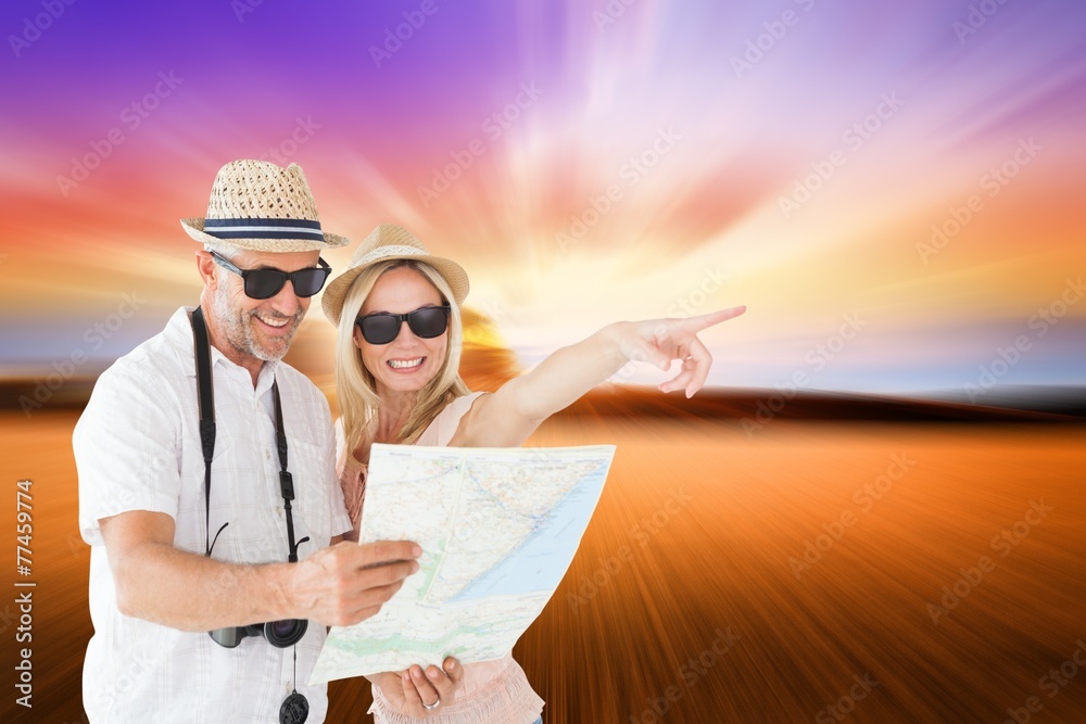 Aufkleber Composite image of happy tourist couple using map and pointing