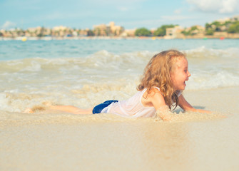 Fototapeta premium Little girl having fun on beach vacation. Place for text.