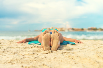 Woman sunbathing on sand. Place for text.