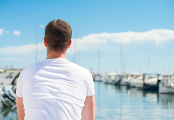 Fototapeta na wymiar Man looking on pier with yachts.