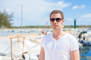 Fototapeta na wymiar Man portrait against of the pier with yachts.