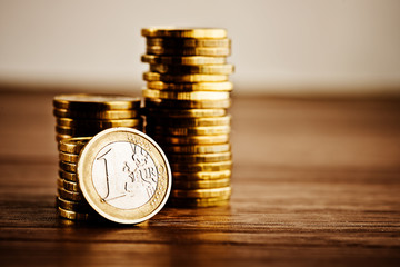 one euro coin and gold money on the desk