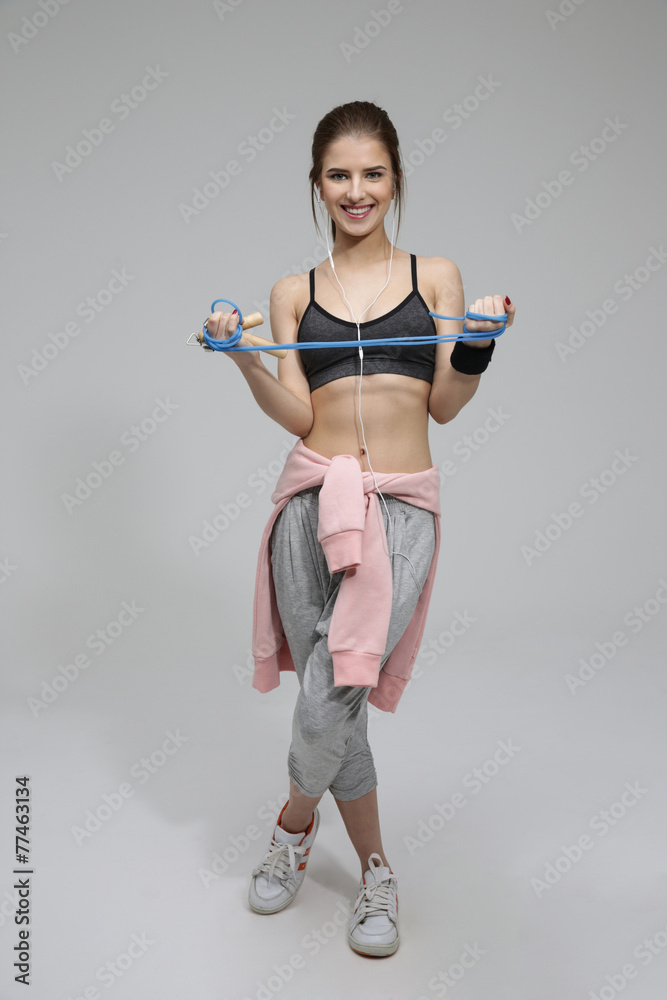 Wall mural Portrait of a beautiful sporty woman over gray background