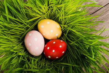 Easter eggs on green grass on wooden table
