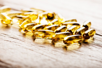 Fish oil omega 3 gel capsules  on wooden background