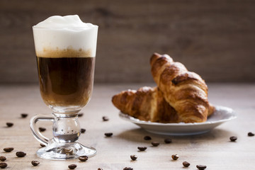a cup of cappuccino with croissant