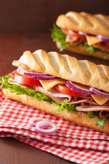 long baguette sandwich with ham cheese tomato and lettuce