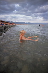 Little boy bathes in the sea