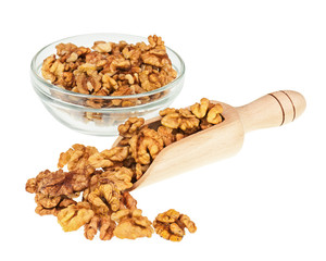 Handful of walnuts in scoop and glass bowl isolated on white.