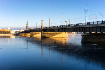 Fototapeta na wymiar Bridge over the frozen river Daugava in Riga in winter