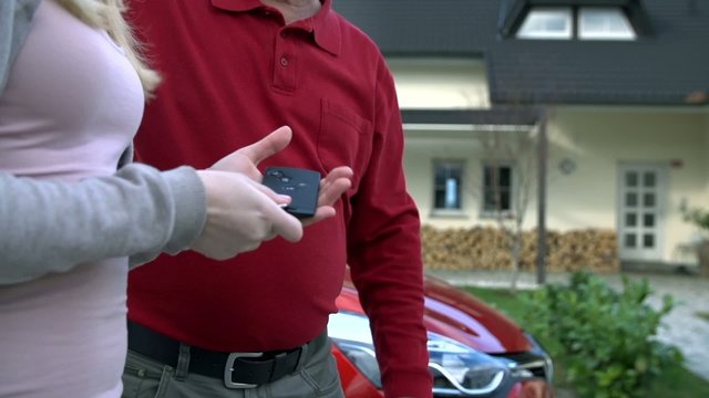 Father passes the car keys to his daughter