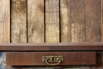 Деревянный стол с ящиком на фоне стены из досок
