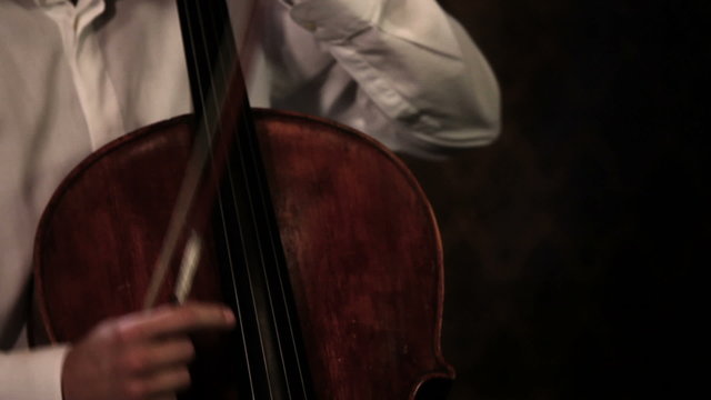 Close up pan shot of a cello player