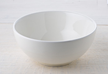 Empty white bowl on wooden table
