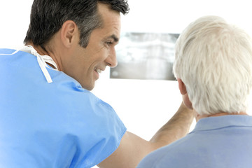 Dentist showing x-ray to senior patient