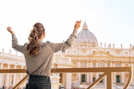 Woman rejoicing in front of basilica di san pietro in Vatican