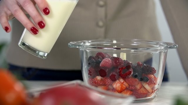Pouring milk into berries 