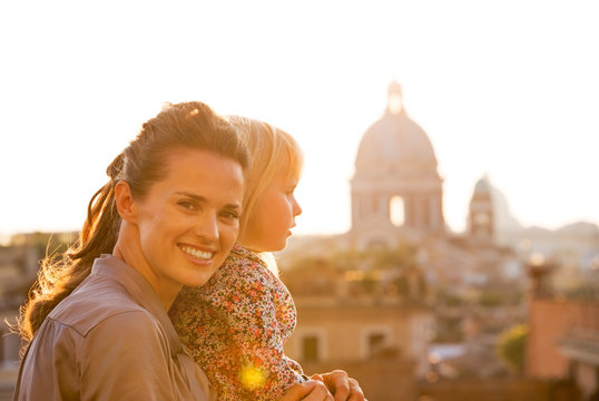Fototapeta Portrait of happy mother and baby girl on street 