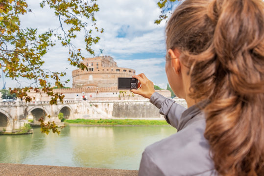 Young woman taking photo of castel sant'angelo in rome italy