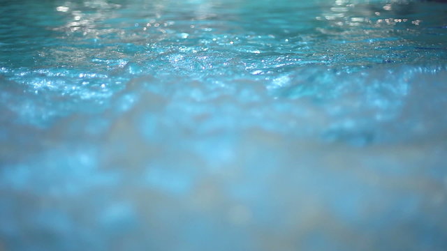bubbles in pool and couple coming together infront of the camera 