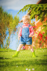 Marvelous little girl plays with on green spring grass