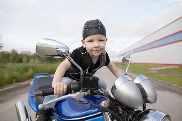 Fototapeta na wymiar little biker on road with motorcycle
