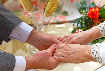 Elderly man and woman holding hands