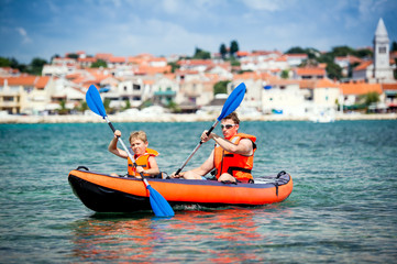 father and son in a kayak - 77479778