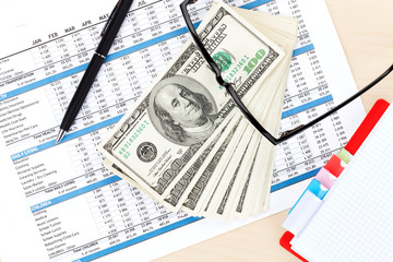 Fototapeta premium Office desk with reports, blank notepad and money cash