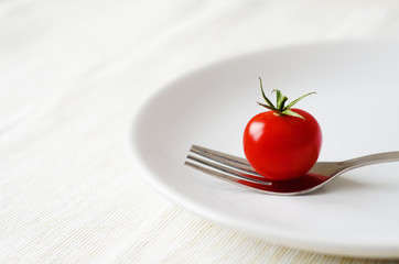 tomato served on white plate with fork
