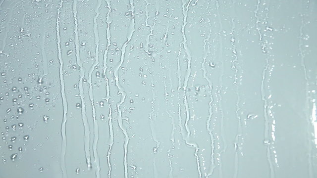 Close up of water drops running on glass