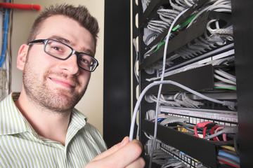 A happy worker technician at work with computer.