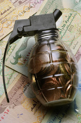 Close up of Transparent grenade filled with coins on emirati dirham notes