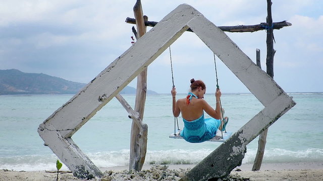 Woman on a swing in Gili Air island, Indonesia