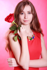 Portrait of a young attractive woman with a red rose