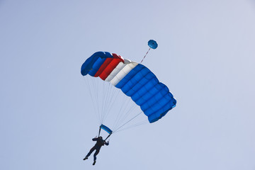Parachutist jumping on a background of blue sky