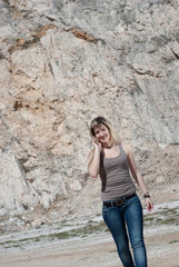 Blonde lady walking, rock mountain as background