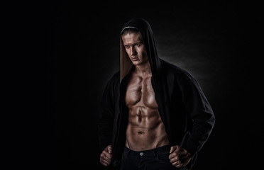 Naklejka na ściany i meble muscular sports man after weights training over black background