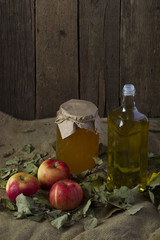 Apples with a jar of honey and a bottle of olive oil