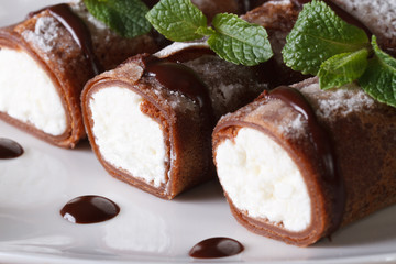 Delicious chocolate crepes with soft cheese and mint closeup