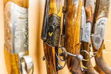 Fotobehang close up of a row of guns displayed in gun shop © joppo