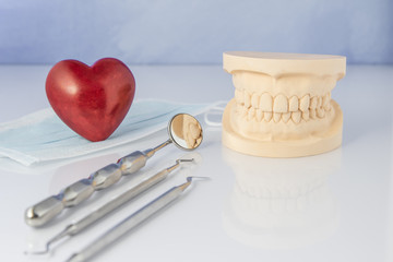 Dental mold with tools of a face mask and red heart.