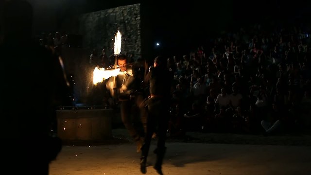 Men fighting with torches and spitting fire