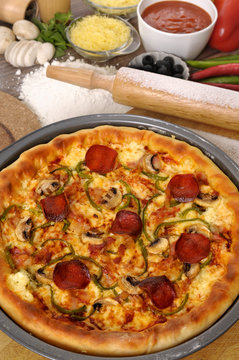 Pizza with ingredients making preparing cooking pan photo
