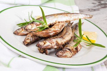 Grilled sardines on plate.