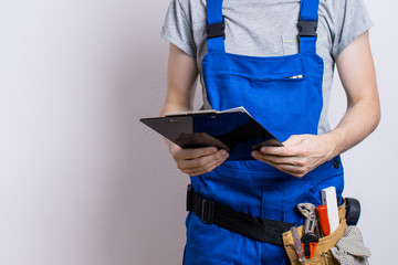 Arbeiter im Blaumann mit Klemmbrett