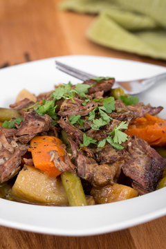 braised beef pot roast stew with vegetables on table