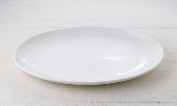 Empty ceramic plate on wooden table