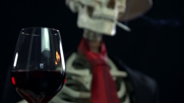 Focus shift from a glass of wine to the skeleton