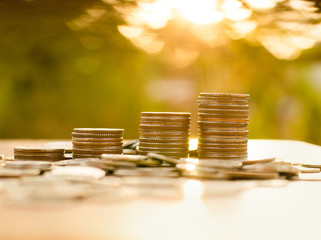 Money coin stack growing graph with sunlight